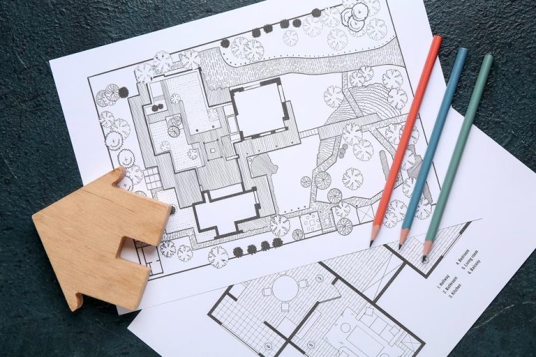 Backyard design process shown through detailed landscape plans, colored pencils, and a wooden house model